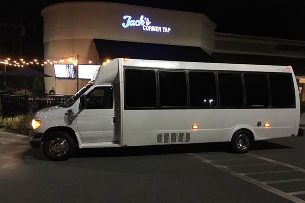 white luxury bus in front of jack's corner tap